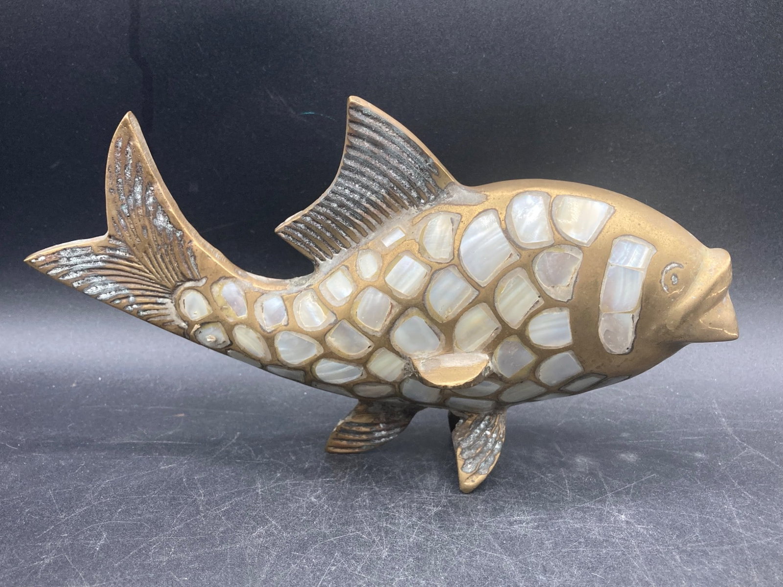9 Brass & Mother Of Pearl Fish Figure: This is a 9-inch fish-shaped figure constructed from brass and inlaid with mother of pearl. The figure features a sturdy body design with intricate scales represented by mother of pearl panels. The br