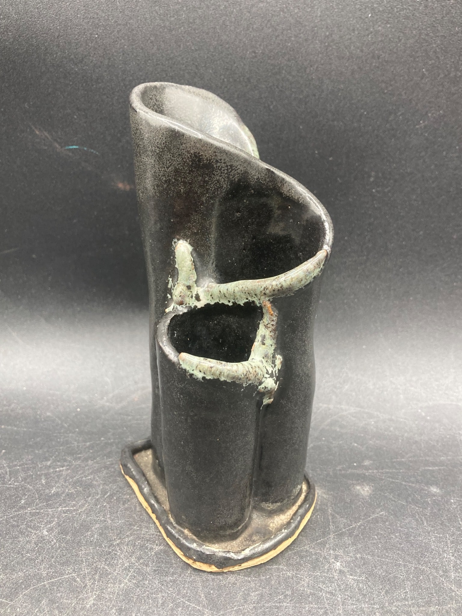 Ilona Pottery Rocket Vase: This item is a pottery vase signed ˜Ilona™ on the base with the numbers 879 and the date 86. The vase features a unique form with a black finish and contrasting green accents. It measures approxima