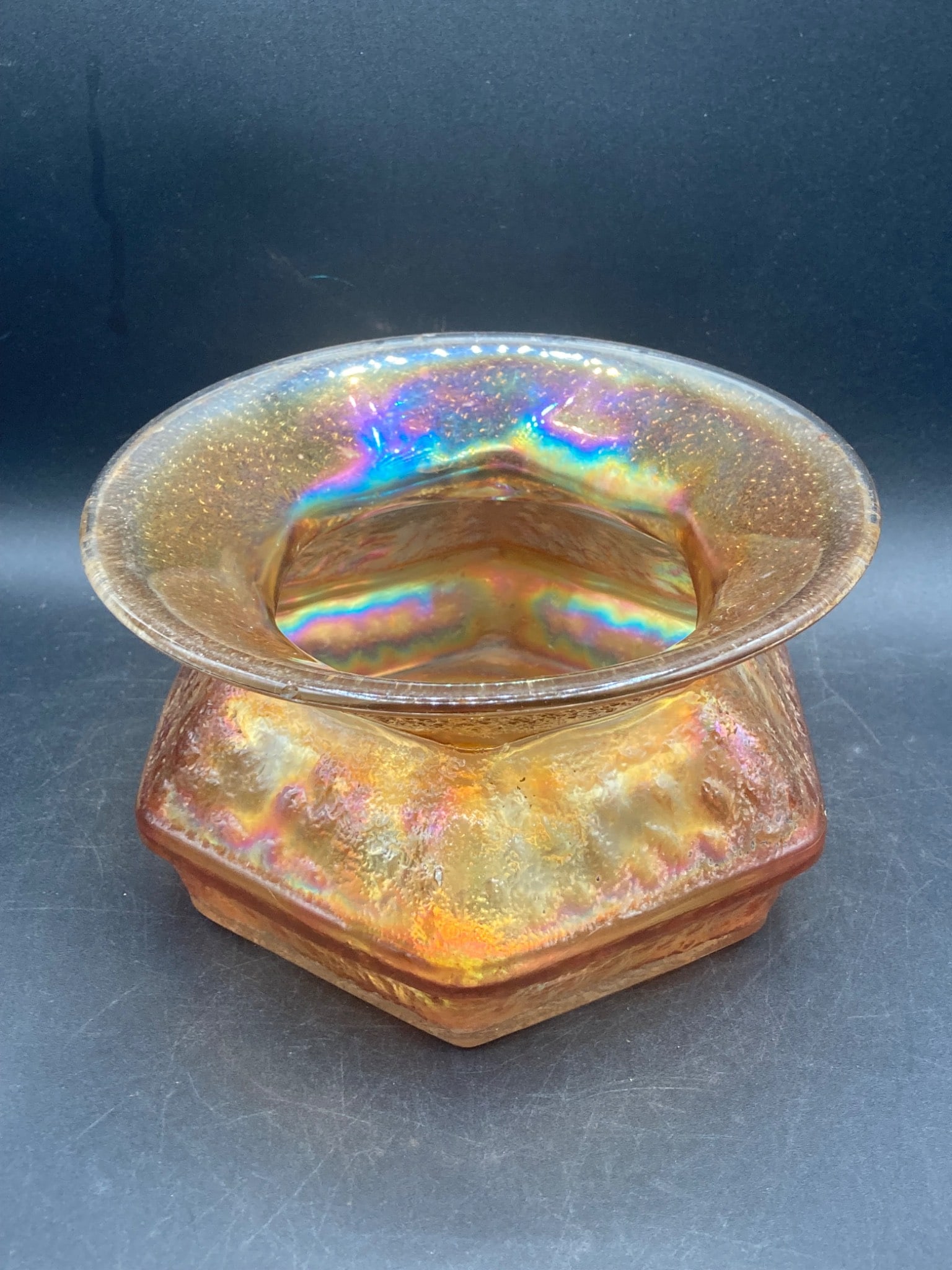 Vintage Carnival Glass Marigold Hexagon Spittoon: This is a vintage carnival glass spittoon featuring a marigold iridescent finish and a hexagonal base. It exhibits a vibrant rainbow sheen typical of carnival glass pieces, with a broad flared rim and