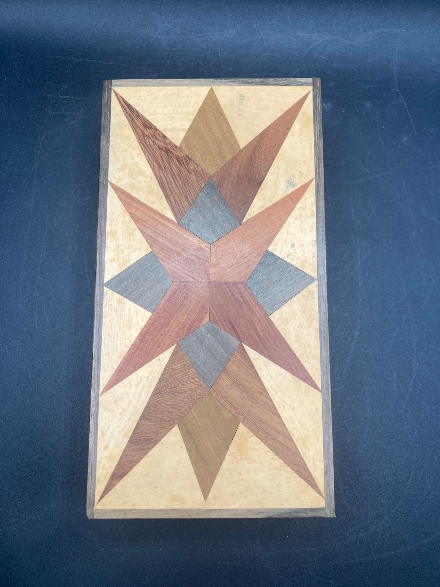 4"x8 Inch Wood Marquetry Box: This is a rectangular wood marquetry box featuring a geometric star motif on the lid, constructed with various inlaid wood types. The box measures approximately 4 inches wide by 8 inches long. It has 