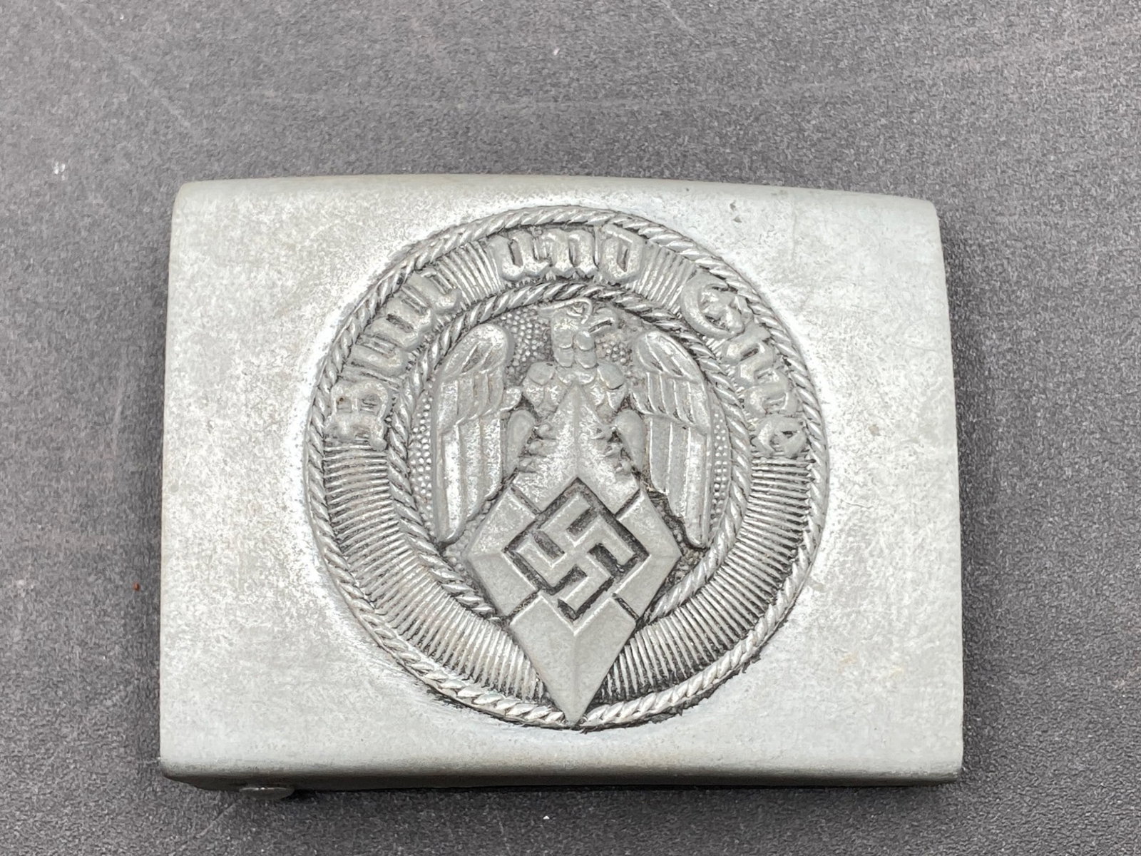 Original WWII German Hitler Youth Belt Buckle With Original Tag: This is an original World War II German Hitler Youth belt buckle. The buckle features the design with the German eagle and the Hitler Youth diamond logo, surrounded by the motto 'Blut und Ehre' (Blood