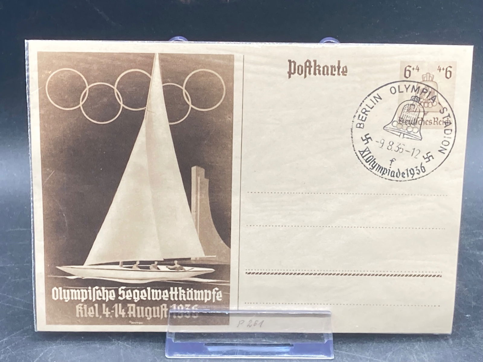 1936 Berlin Olympics Sail Racing Postcard: This is an original 1936 Berlin Olympics postcard highlighting the sailing events held in Kiel between August 4-14, 1936. The postcard showcases an image of a sailboat beneath the Olympic rings and fe