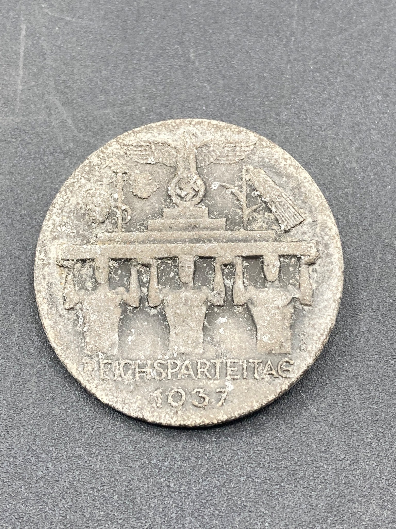 1937 German Reichsparteitag Tinnie, Werner Redo: Circular tinnie from the 1937 Reichsparteitag (Nazi Party Congress), featuring an eagle with a swastika and other symbols on the obverse. Inscribed 'Reichsparteitag 1937'. The reverse side includes th