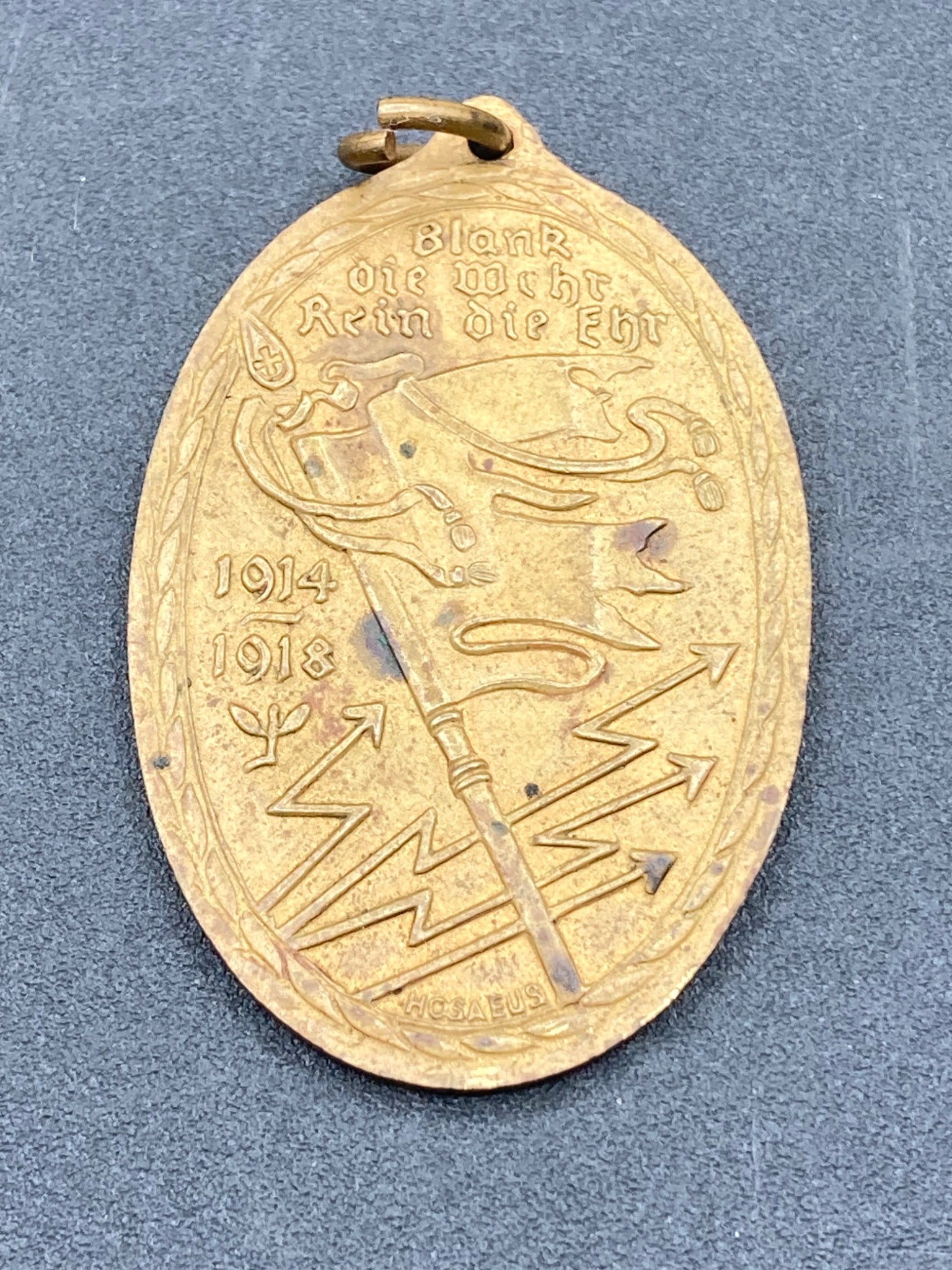 Prussian War Veteran Tag: This item is a Prussian War Veteran commemorative tag, featuring inscriptions linked to World War I. The front is embossed with the years 1914-1918, symbols related to military service, and text 'Blan