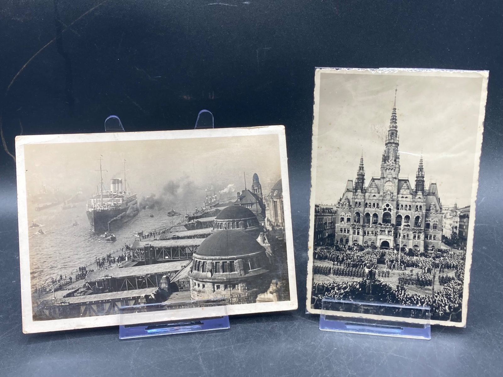 WWII German Postcards: This lot includes two original WWII-era German postcards. The first depicts a bustling waterfront scene in Hamburg with a ship and port activity, while the second shows a historically significant buil