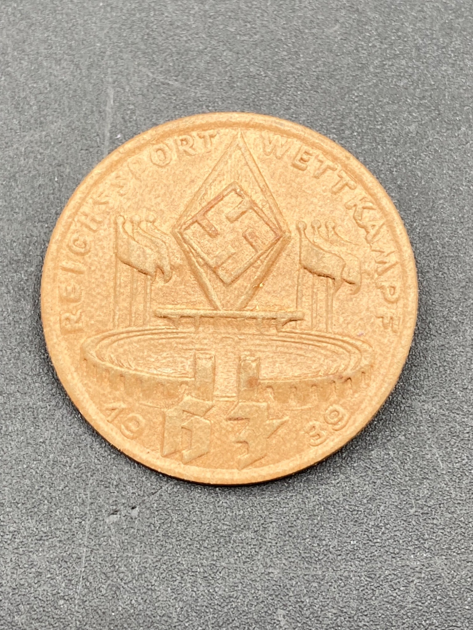 WWII German Hitler Youth Reichssport Wettkampf Tinnie Badge 1939: This is a WWII-era German Hitler Youth Reichssport Wettkampf tinnie badge, issued in 1939. The pressed paper badge features detailed inscriptions, including the year "1939" and the words 'Reichssport 
