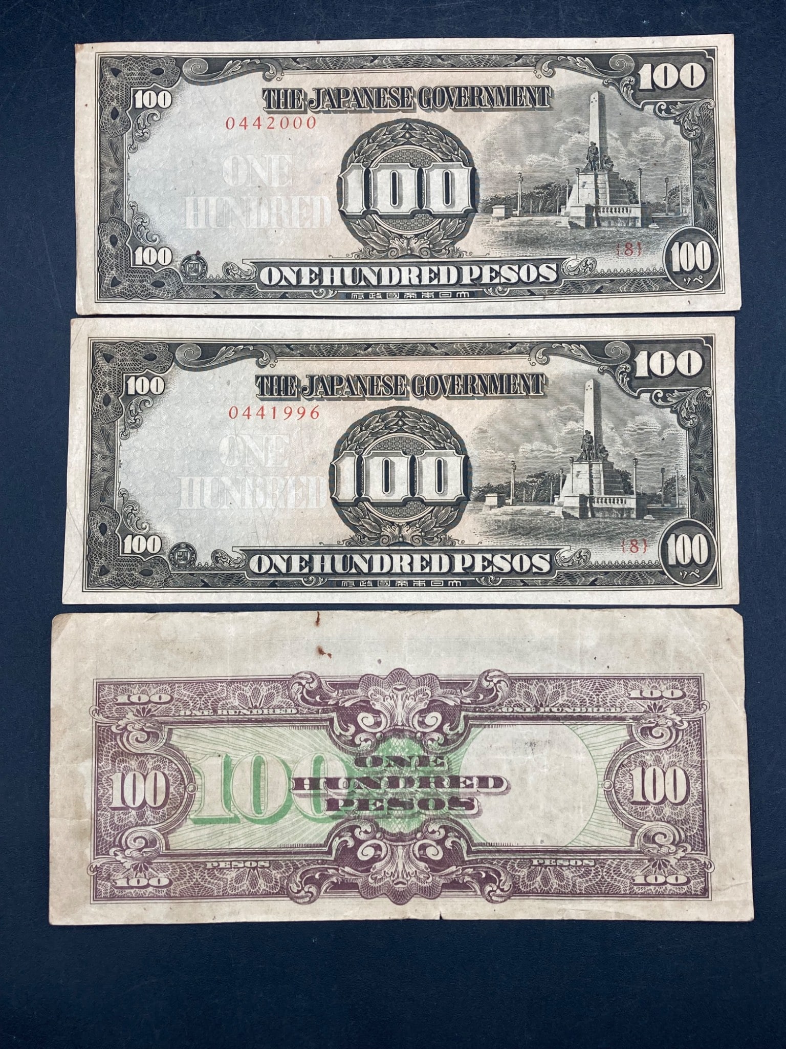 1940s Japanese Occupation Philippines 100 Peso Notes, Set of Three: Set of three 100 Peso notes issued during the Japanese occupation of the Philippines in the 1940s. Each note features 'The Japanese Government' header, Rizal Monument on the front, and detailed engrav