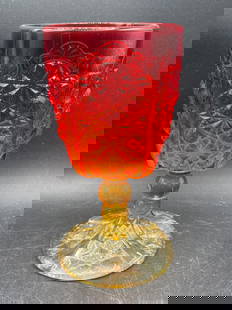 Pressed Glass Amberina Buttons Goblet: This is a pressed glass goblet with a vibrant red-to-amber color gradient, featuring ornate faceted Daisy and button designs. The item has a textured stem and base with a symmetrical pattern.