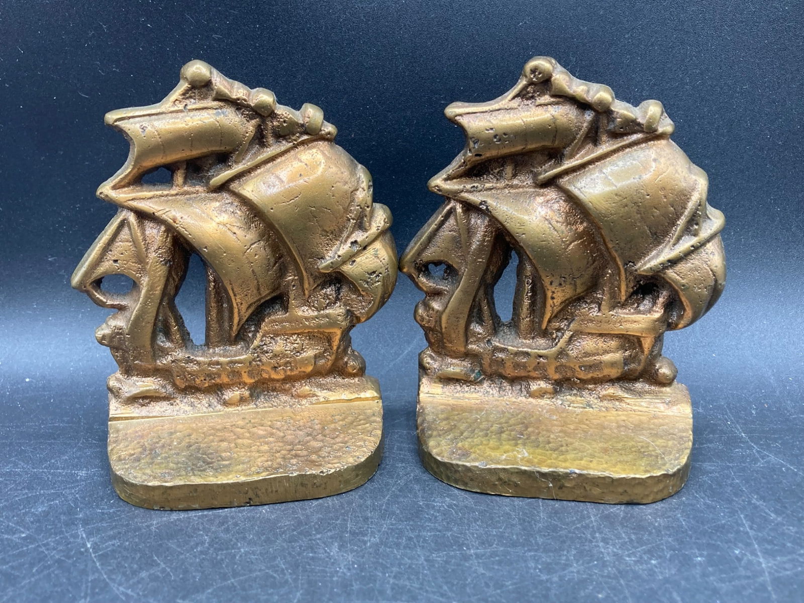 Vintage Brass Sailing Ship Bookends: This lot includes a pair of brass sailing ship bookends featuring intricate detailing of ship sails and rigging. The bookends measure approximately 4 tall and are constructed from solid brass with a t