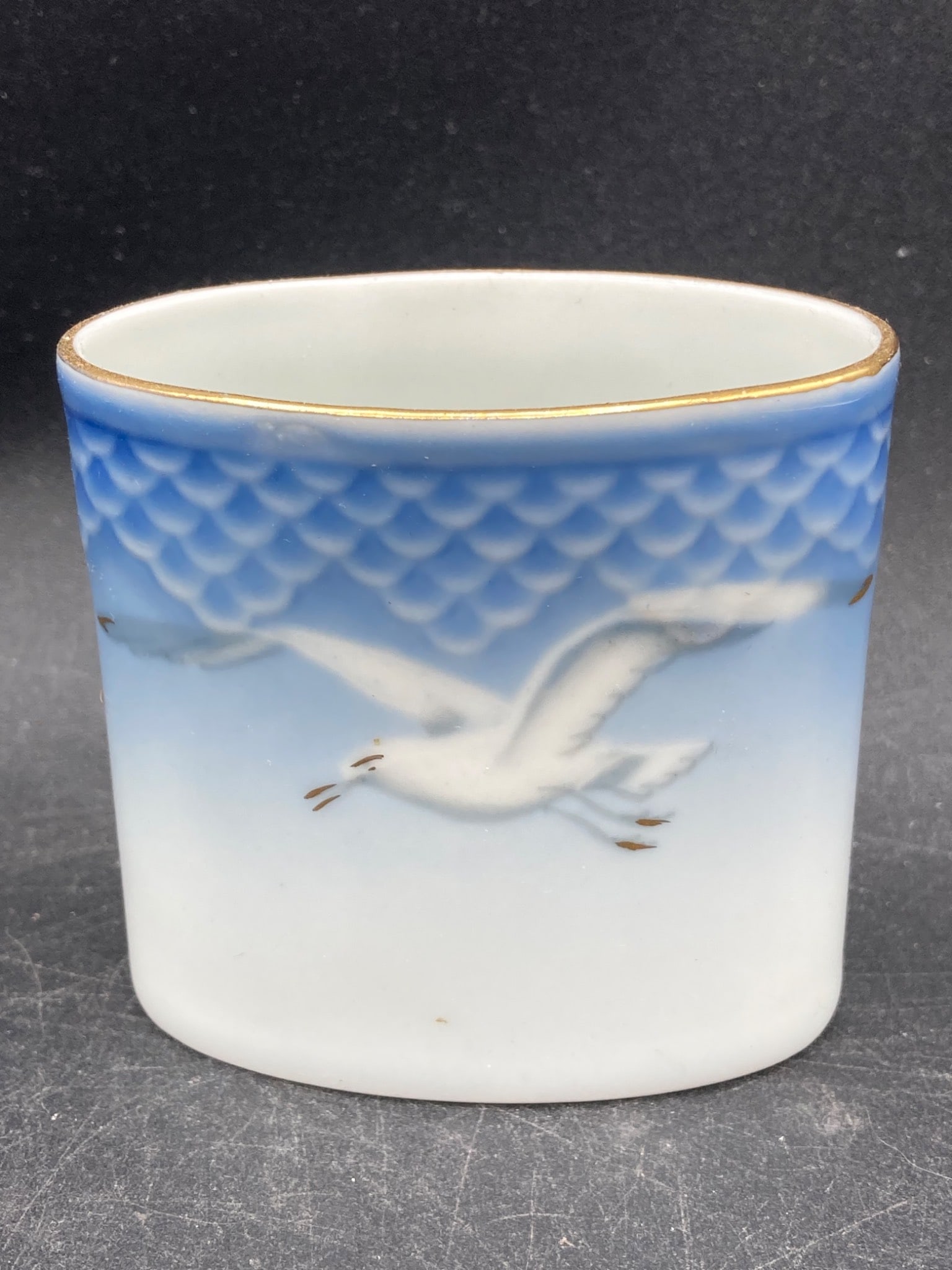 Royal Copenhagen Porcelain Cup with Seagull Pattern, Model 369: Royal Copenhagen porcelain cup featuring the iconic seagull design with blue and white gradient and gold rim. The base is marked with '369' as the model number and 'Made in Denmark'. The piece measure
