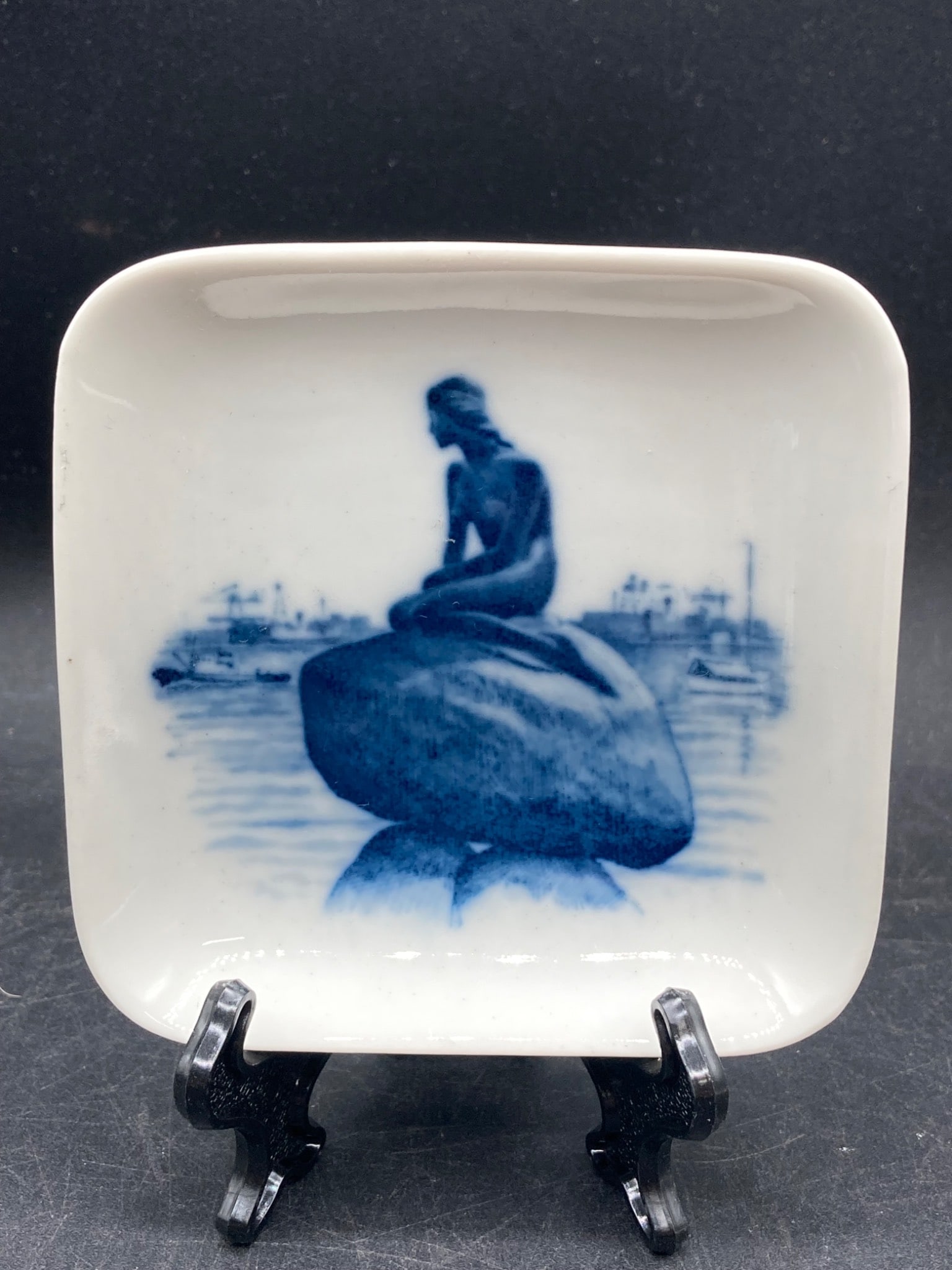 Royal Copenhagen Porcelain Dish Featuring Little Mermaid, Model 2985-13: This is a Royal Copenhagen square porcelain dish decorated with the iconic 'Little Mermaid' statue in cobalt blue. The marking on the back includes the 'Royal Copenhagen Denmark' logo and model number
