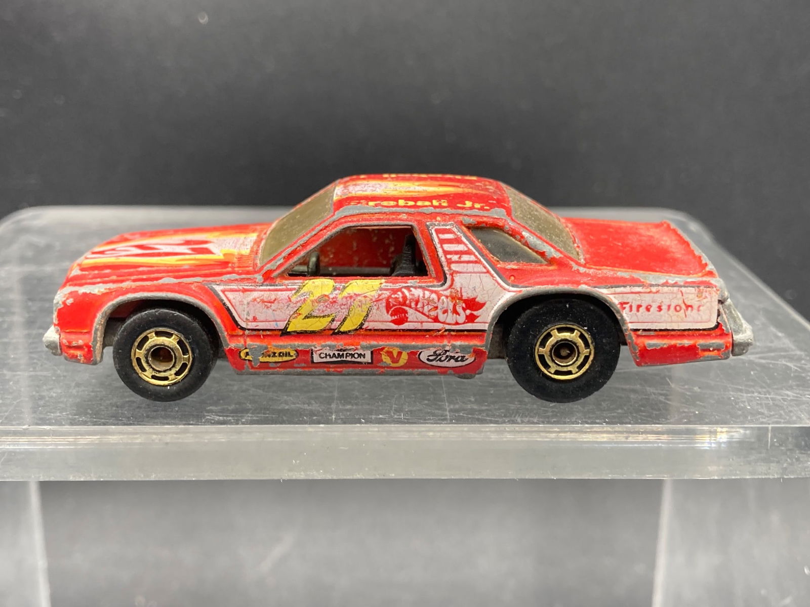 Vintage Hot Wheels 1/64 Fireball Jr. Fairmont Die-Cast Car: Hot Wheels Fireball Jr. Fairmont 1/64 scale die-cast model car, model #9691. Features a red body with flame designs and detailed sponsor logos including Firestone, Champion, STP, and Valvoline. Manufa