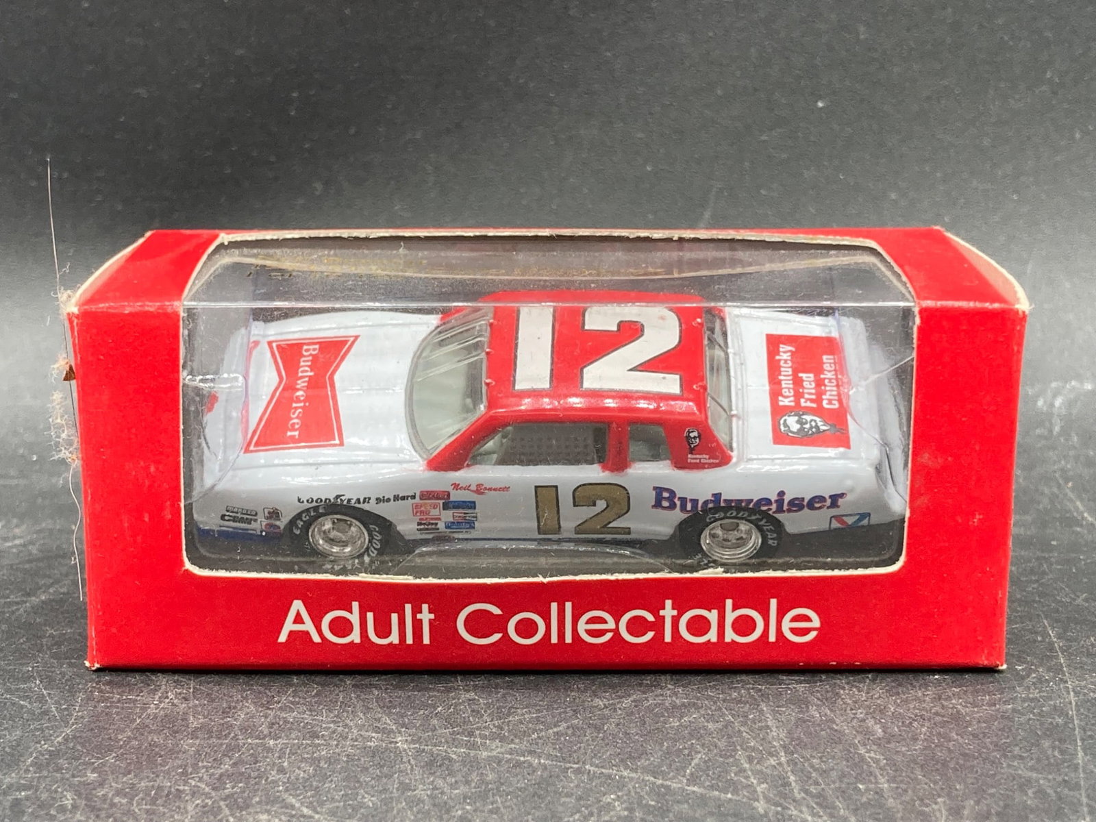 Action Racing 1/64 Neil Bonnett 1984 Monte Carlo Die Cast Collectible: Action Racing 1/64 scale Neil Bonnett 1984 Monte Carlo die-cast car. Features Notchback design and #12 Budweiser racing livery. Manufactured as part of a limited run, with '1 of 16,128' etched on the 