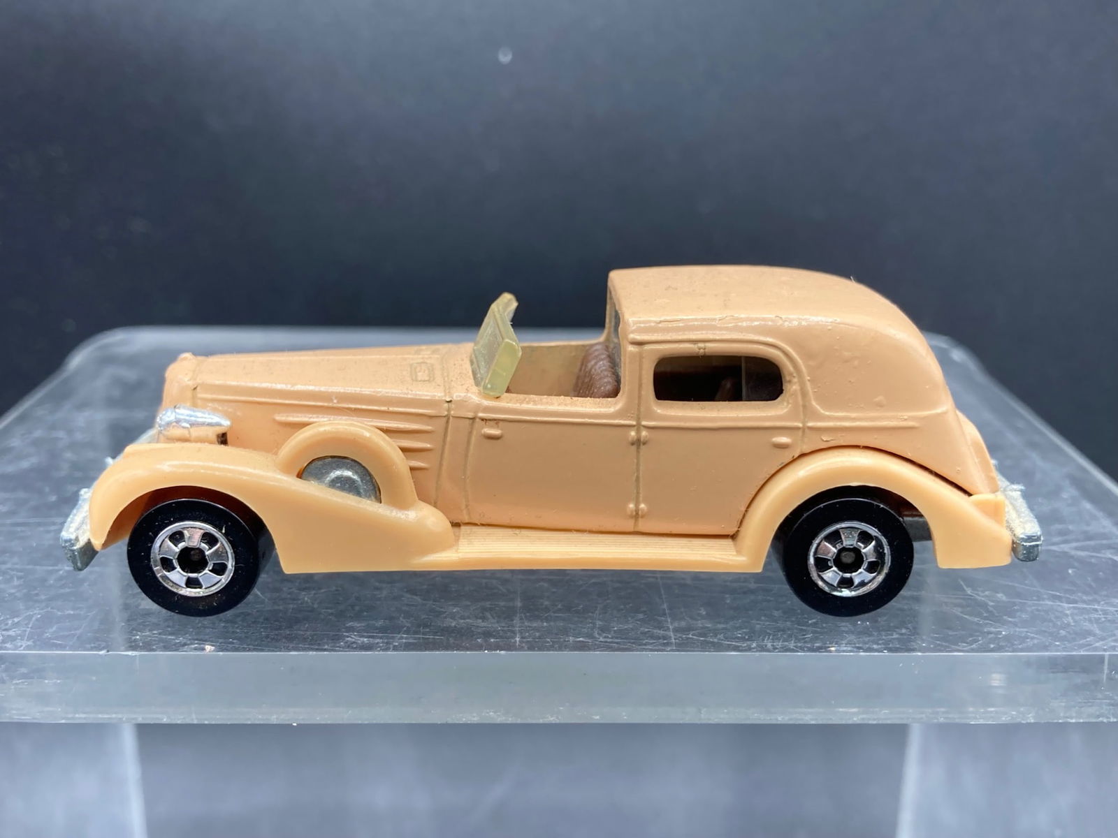 Vintage Hot Wheels 1:64 Classic Caddy Die-Cast: This is a Hot Wheels Classic Caddy die-cast toy car manufactured in 1982. Featuring a tan-colored body, the base indicates 'Hot Wheels, Classic Caddy, Mattel Inc., 1982, Hong Kong.' It has chrome deta