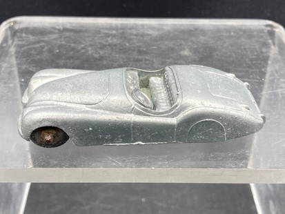 Vintage Tootsietoys Jaguar Die Cast Toy Car: This is a vintage Tootsietoys Jaguar die-cast toy car, produced circa 1940s. The toy features a convertible design with detailed interior dashboard and steering wheel, visible on close examination. Th
