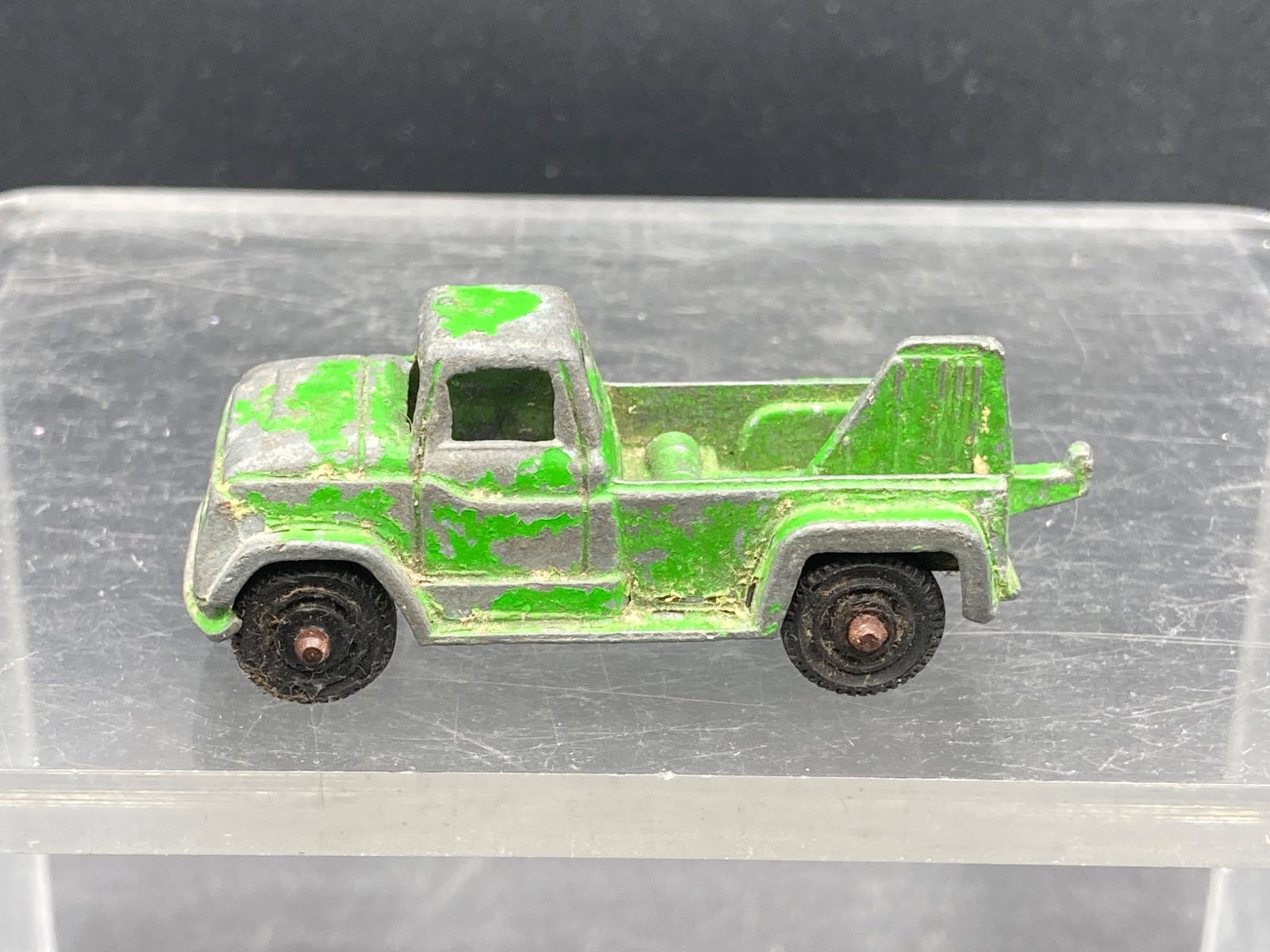 Vintage Tootsietoys Tow Truck Die Cast Toy, Green: This listing is for a vintage Tootsietoys die-cast tow truck toy, featuring green paint and a tow hook design. The toy displays wear consistent with age, including visible paint loss and signs of surf