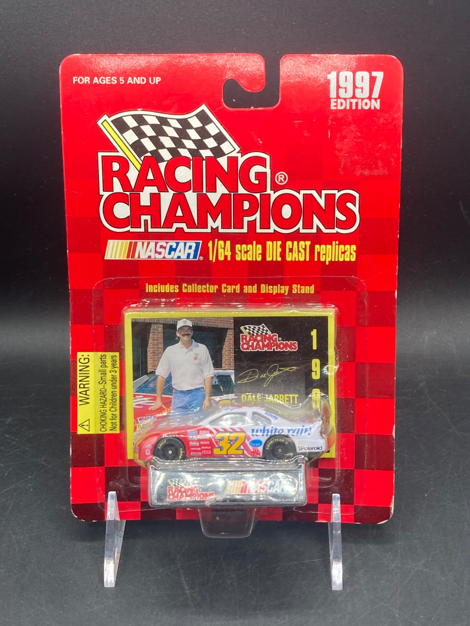 Racing Champions 1/64 1997 Dale Jarrett NASCAR Stock Car Die Cast: 1997 Racing Champions 1/64 scale NASCAR die cast stock car featuring Dale Jarrett's #32 car with 'White Rain' livery. Includes collector card and display stand. Original packaging is intact with minim