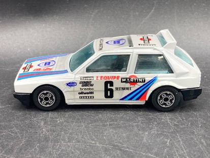 Burago 1/43 Lancia Delta S4 Diecast Model Car, Martini Livery: This is a Burago 1/43 scale diecast model car of the iconic Lancia Delta S4 in Martini Racing livery. Constructed in Italy, this model features intricate sponsor decals and branding details replicatin