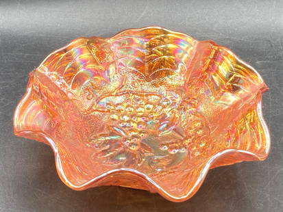 Carnival Glass Marigold Bowl with Grape and Vine Pattern: This is a carnival glass marigold bowl featuring a grape and vine pattern. The shallow, ruffled bowl measures approximately 5 inches in diameter. The iridescent finish displays hues of orange, gold, a