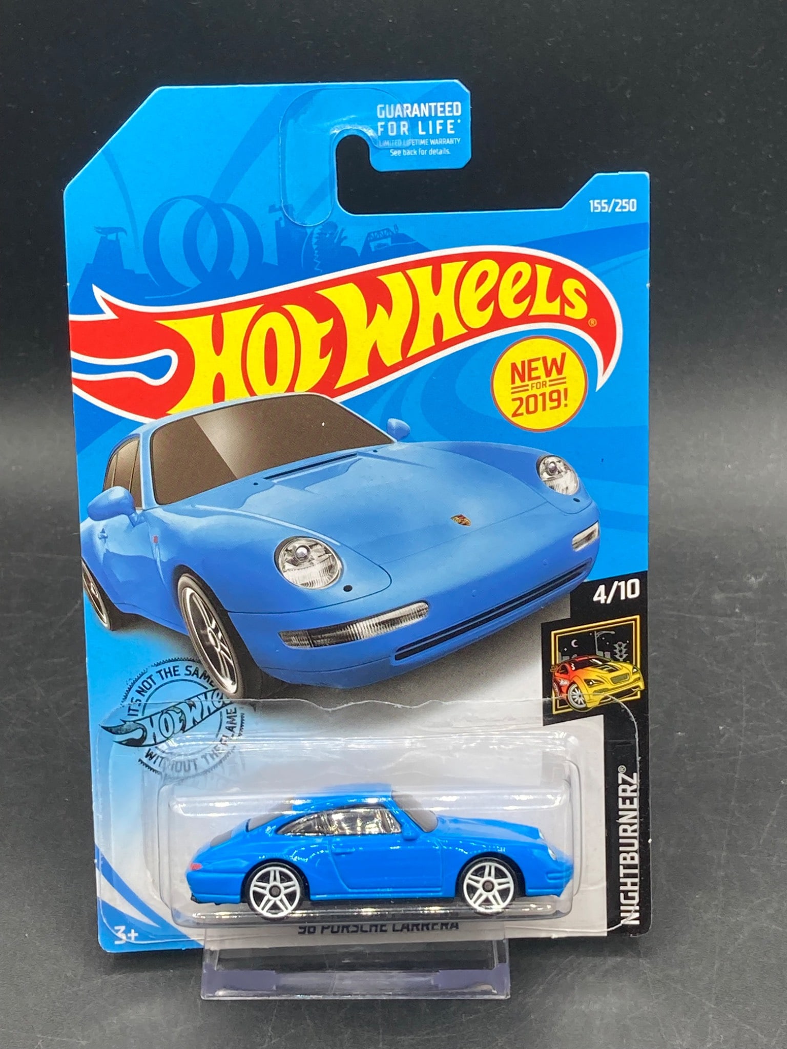 Hot Wheels 1996 Porsche Carrera Die-Cast, Blue (Nightburnerz Series): This is a Hot Wheels die-cast model of the 1996 Porsche Carrera in blue from the Nightburnerz series. The model, labeled as FY81-D9C0M, is part of the 2019 lineup and is number 155/250 in the Hot Whee