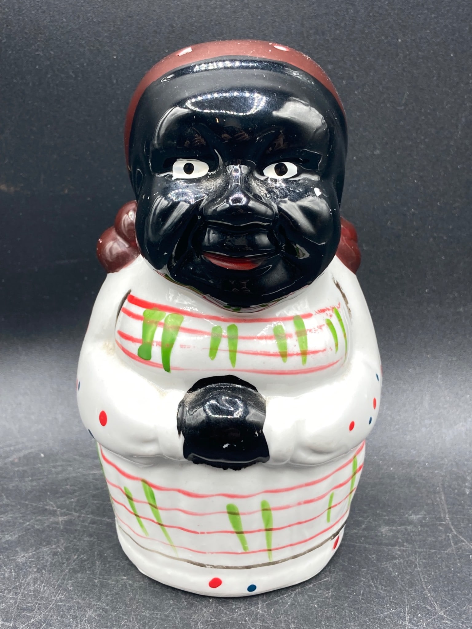 Large Black Americana Porcelain Salt Shaker: This is a large porcelain salt shaker featuring a Black Americana design. The shaker is approximately 5.5 inches in height and is finished with hand-painted details in black, white, red, green, and bl