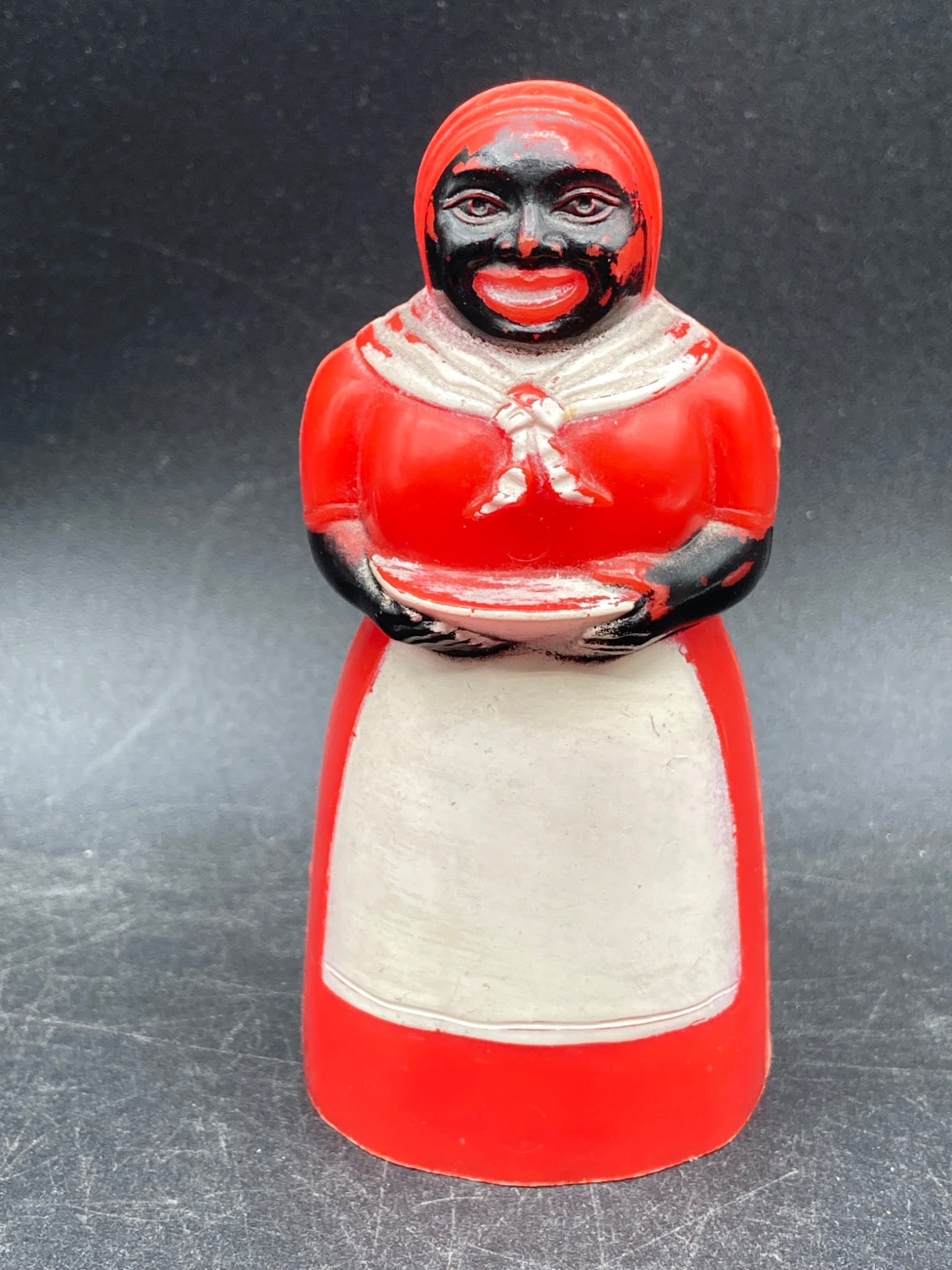 Vintage Black Americana Nutmeg Dispenser: This item is a Black Americana nutmeg dispenser made of molded plastic. Measuring approximately 4 inches in height, it features the inscription 'Made in U.S.A.' at the bottom along with manufacturer m