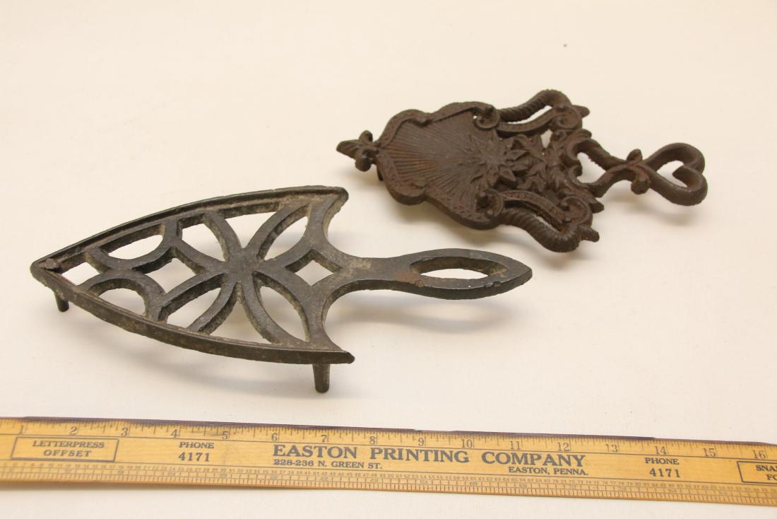 PR. OF TRIVETS: PR. OF TRIVETS CAST IRON TRIVET 10 1/2" AND HEARTS DESIGN TRIVET 9" Dimensions: