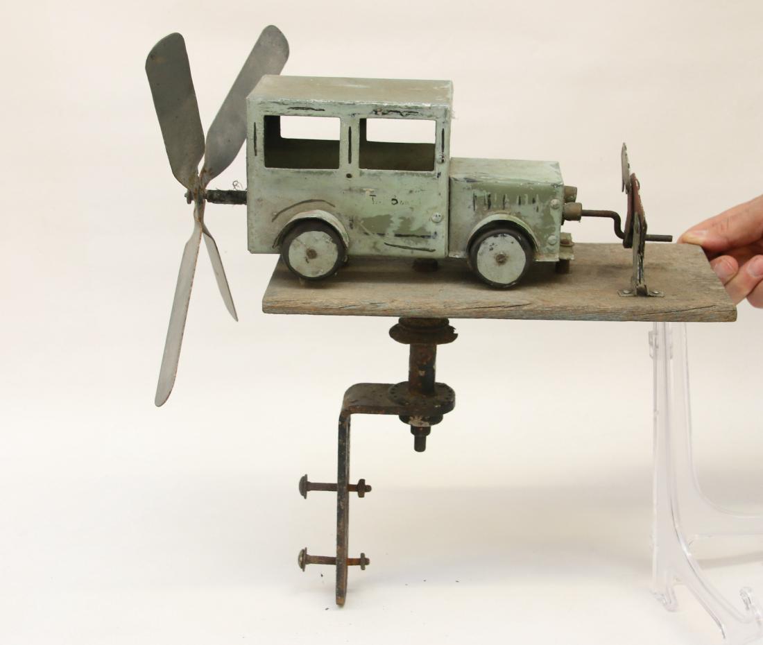 VINTAGE WHIRLYGIG: METAL AND WOODEN DEPICTING AN AUTO WITH DRIVER CRANKING ENGINE Dimensions: 15" X 16"