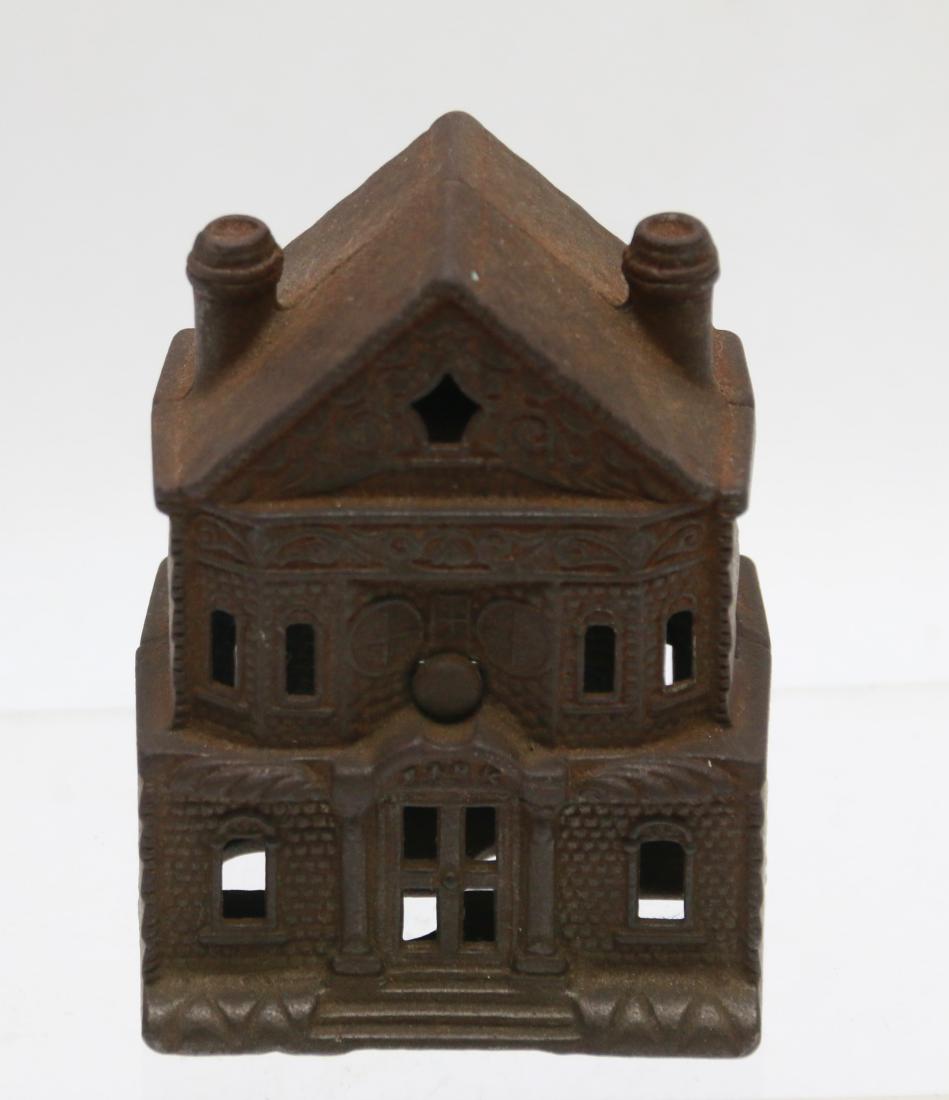 CAST IRON STILL BANK: IN THE FORM OF A HOUSE WITH 2 CHIMNEYS Dimensions: 4 1/2" X 3 1/4"