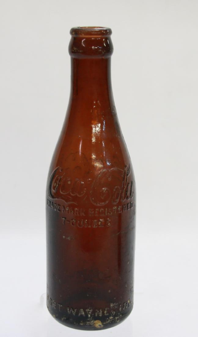 STRAIGHT SIDED COCA COLA BOTTLE: IN AMBER MARKED FORT WAYNE, INDIANA - COCA COLA WRITTEN IN CURSIVE ON BOTTOM Dimensions: 7 1/2"