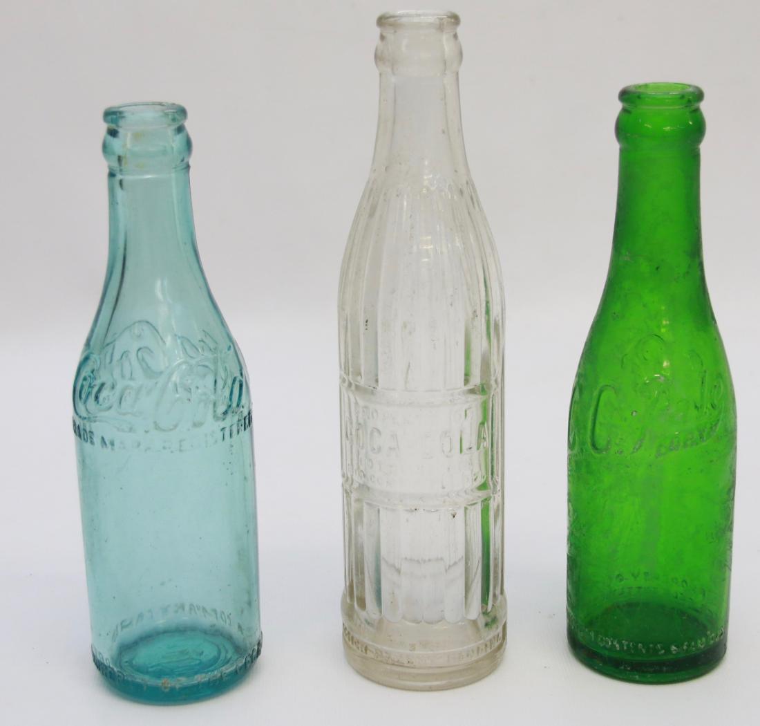 GROUP LOT OF COCA COLA BOTTLES: (3) BOTTLES INCLUDING - CLEAR BOTTLE PROPERTY OF COCA COLA, AQUA STRAIGHT SIDED COCA COLA (MARKED COCA COLA ON BOTTOM), AND GREEN CC PALE DRY MARKED BETHLEHEM ON BOTTOM Dimensions: 8 1/2" - 7 1/2" - 7