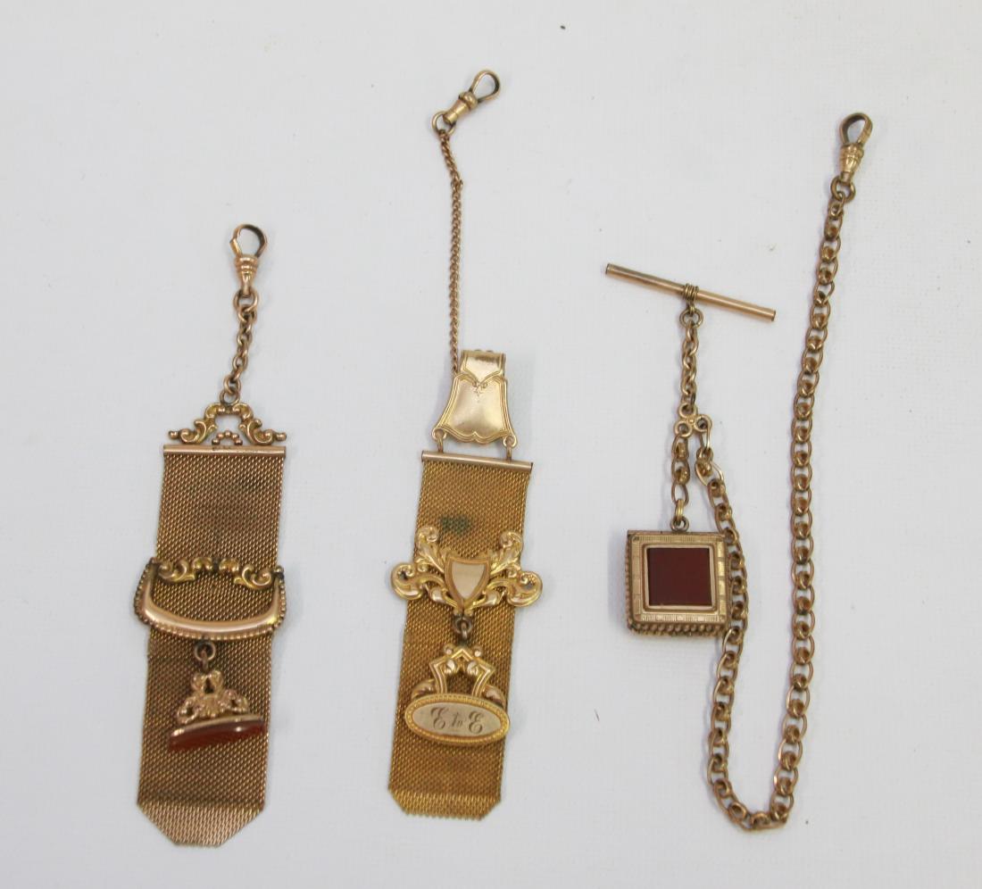WATCH CHAIN AND FOB LOT: LONG WATCH CHAIN WITH LOCKET AND (2) GOLD PLATED FOBS Dimensions: CHAIN 13 1/2" - FOBS 6" AND 8"
