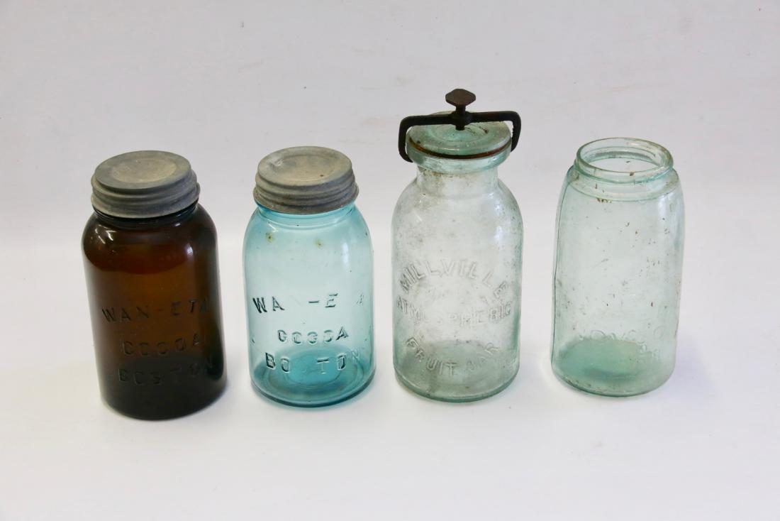 GLASS STORAGE JAR LOT: (4) INCLUDING - MILLVILLE FRUIT JAR WITH ENCLOSURE(CHIP TO LID), WAN-ETA COCOA BOSTON IN CLEAR AND AMBER JARS, AND MASONS JAR 1858 (NO LID AND RIM CHIP)