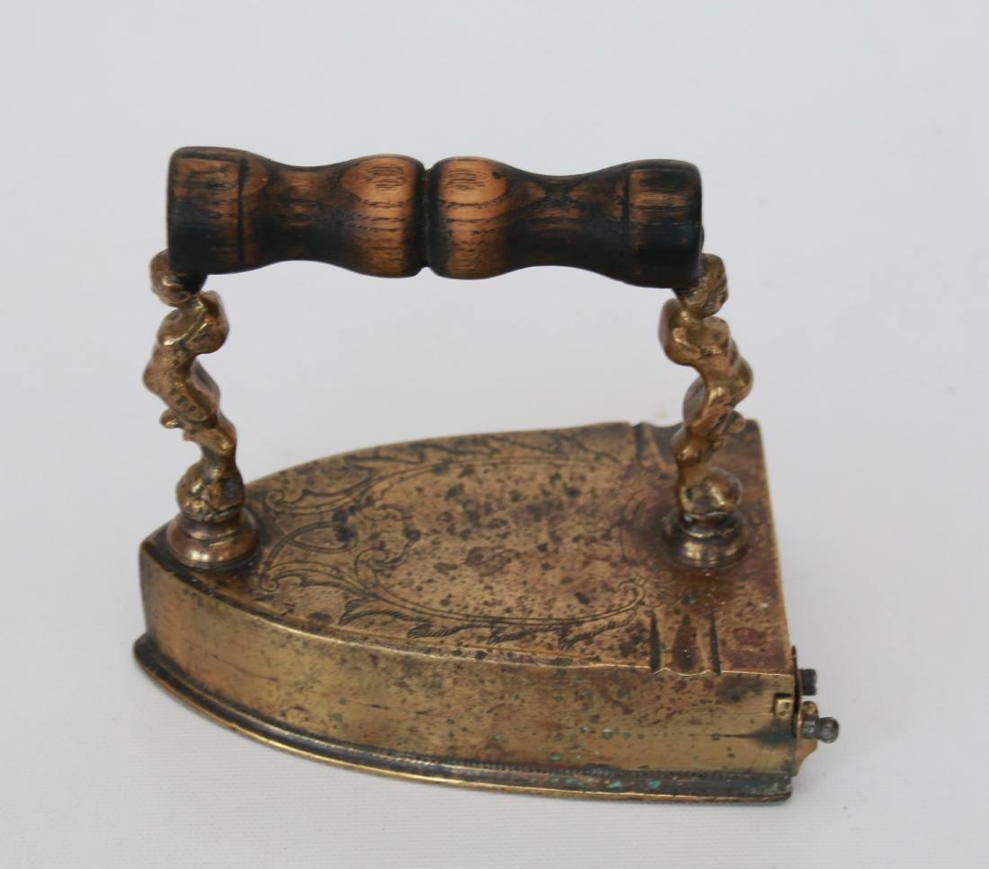 EARLY BRASS SLUG IRON: MANIKIN POSTS, ENGRAVING AND EXTENDED SOLE PLATE . 5 1/4"