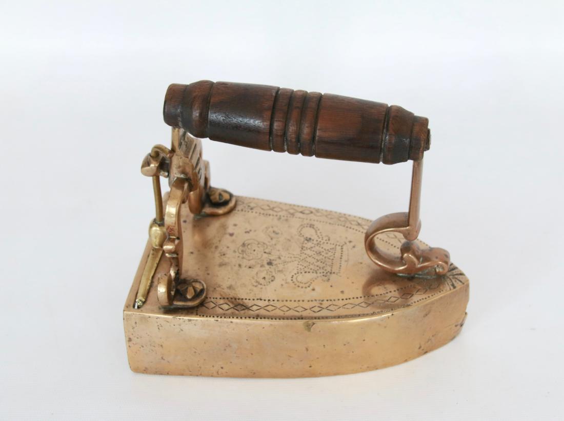EARLY BRASS SLUG IRON: LIFT UP GATE WITH DECORATED POSTS, ENGRAVED TOP, AND WOODEN HANDLE - CIRCA EARLY 1800'S . 7"
