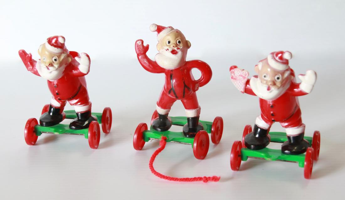 GROUP LOT OF PLASTIC CHRISTMAS DECORATIONS: (3) SANTA CLAUSES ON WHEELS Size:4 3/4"