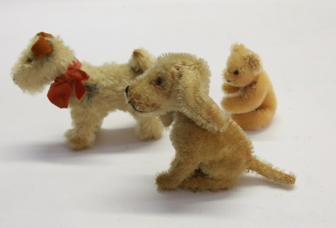 GROUP OF MINIATURE STEIFF ANIMALS: THREE INCLUDING: DOG WITH BOW AND BELL, SITTING DOG WITH GLASS EYES AND BEAR WITH PAPER TAG