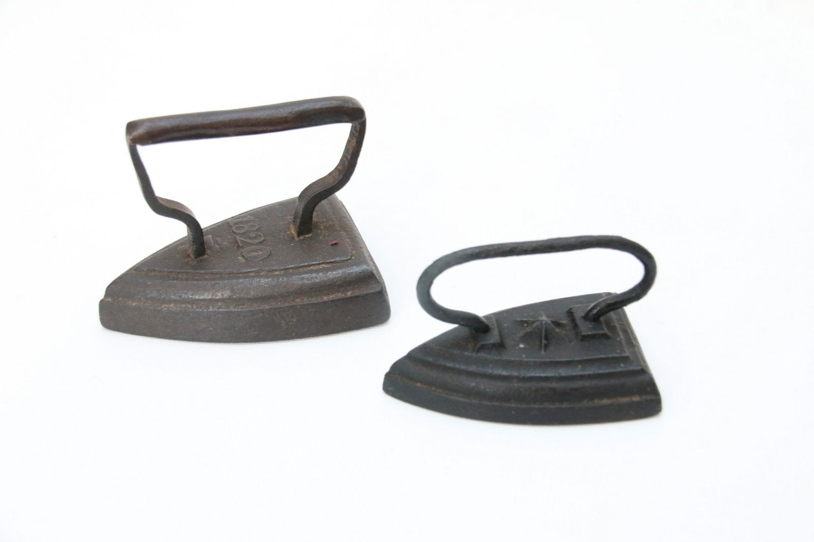 PAIR OF SMALL SIZE SAD IRONS: EMBOSSED STAR AND ONE WITH EMBOSSED DATE OF 1820 Size: 3" AND 2 5/8"