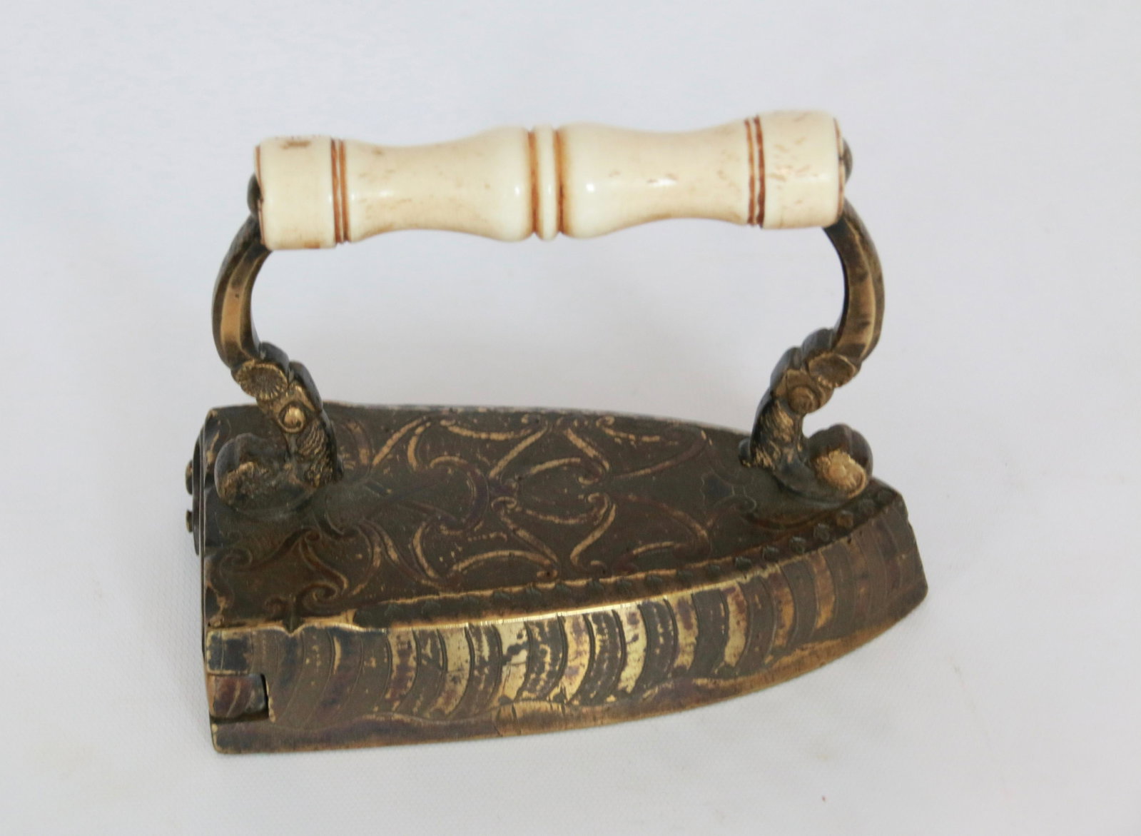 BRASS SLUG IRON: BONE HANDLE WITH ELABORATE POSTS AND SIDES WITH ORIGINAL SLUG Size: 6"