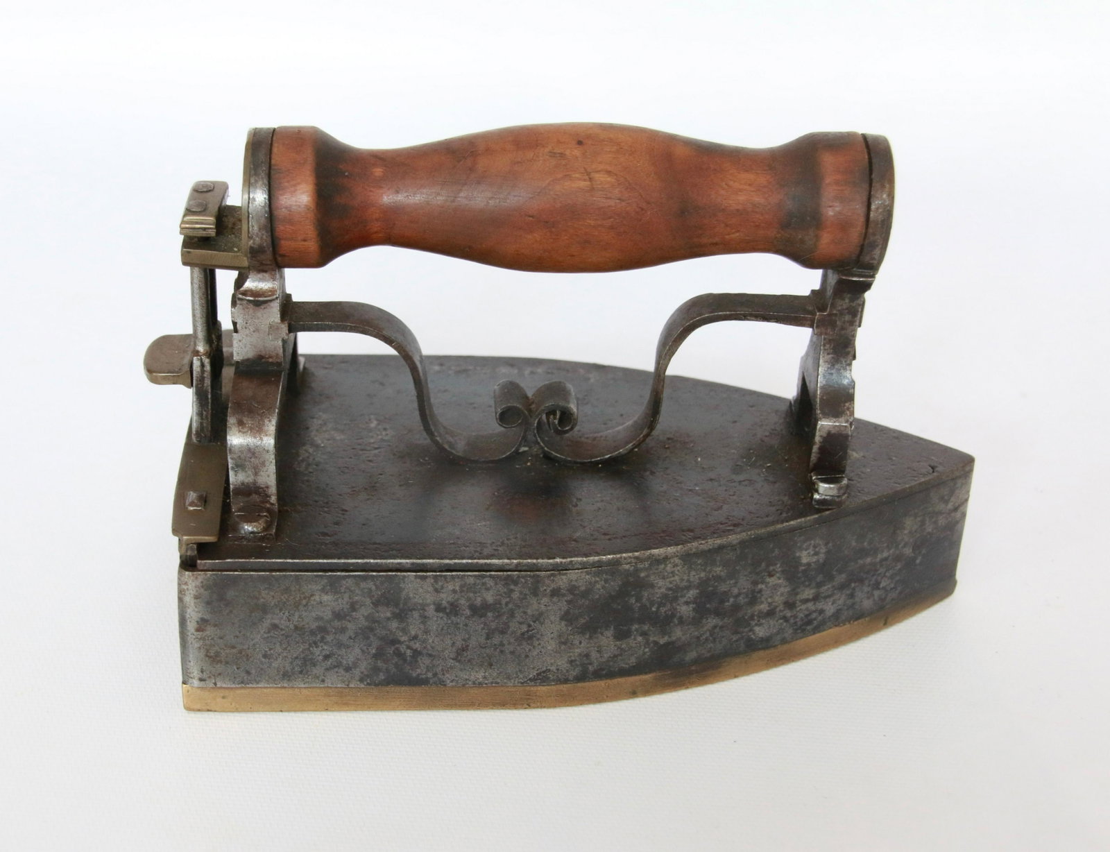 HANDMADE SLUG IRON: HAND MADE SLUG IRON WITH MONKEY TAILS, BRASS SOLE, AND ELABORATE LIFT GATE Size: 6 1/2"