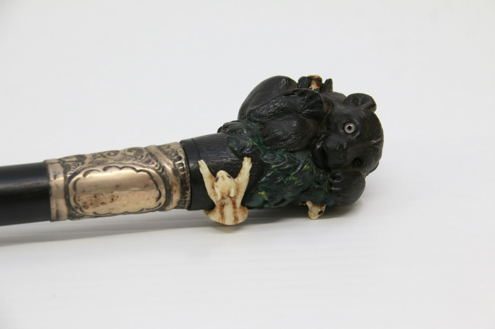 19TH CENTURY EBONY AND BONE WALKING STICK: EBONY AND BONE WALKING STICK WITH CARVED BEAR CUB, CHIPMUNKS, AND WOODPECKER - STERLING BANDED - AMERICAN Size: 35 3/4"