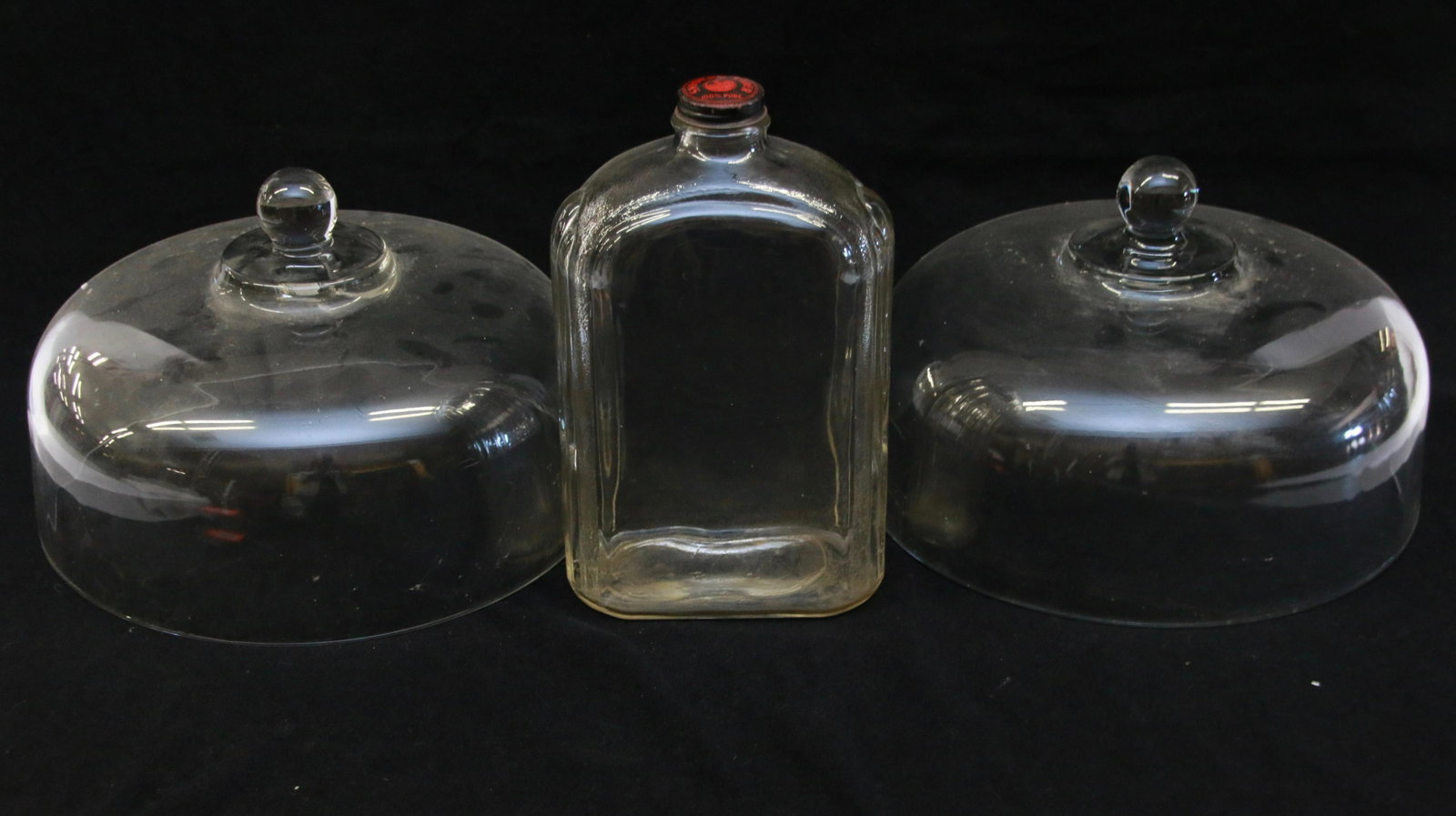PAIR OF GLASS DOMES: HEAVY GLASS WITH LIFTING KNOBS. ALSO INCLUDES SNYDER'S CIDER BOTTLE. 11" X 7 1/4". BOTTLE 10" X 5 1/2"