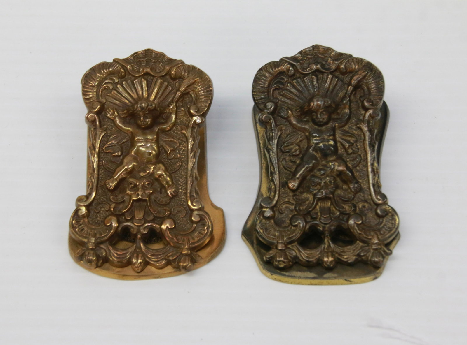PAIR OF CHERUB BILL CLIPS: INCLUDING: ONE BRONZE(MRKD. 5254) AND ONE BRASS (MRKD. 5277) 3 1/2" X 2 1/8" AND 3 1/2" X 2 1/4"
