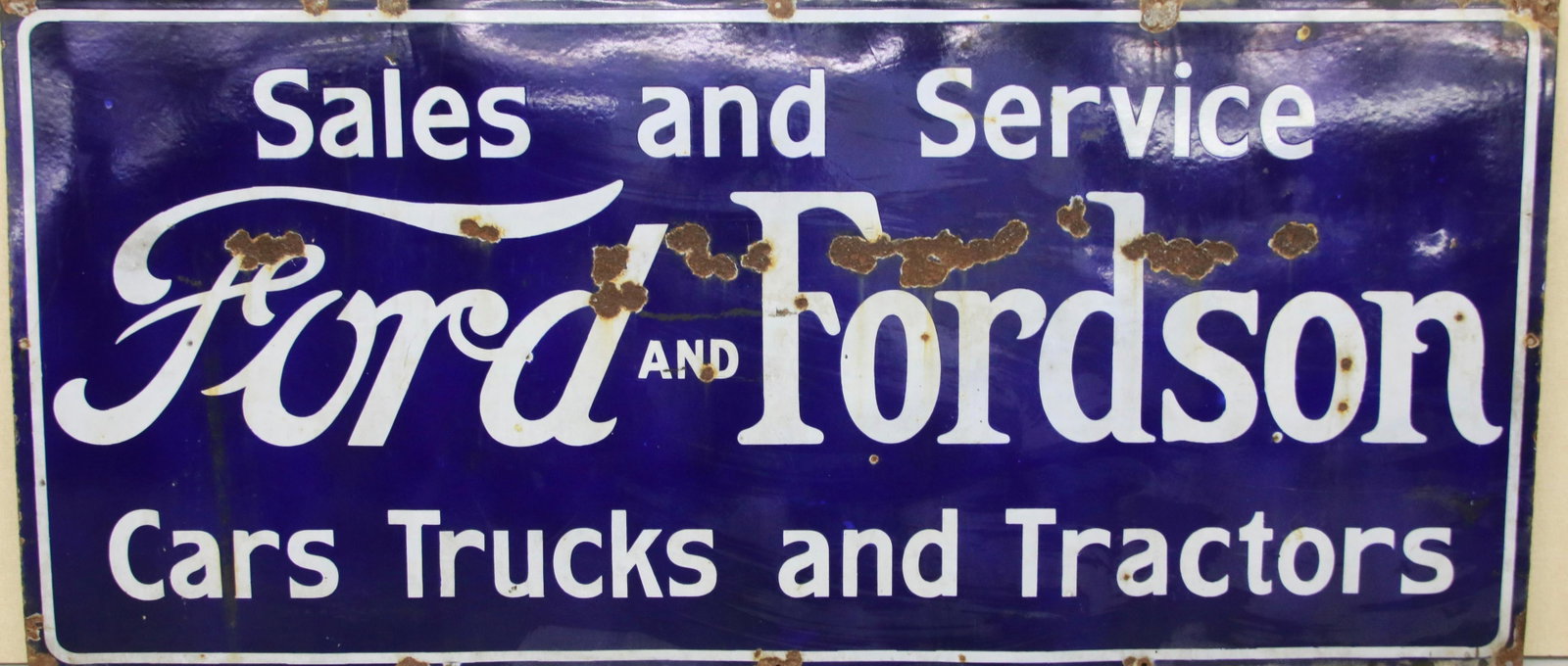 FORD PORCELAIN ADVERTISING SIGN: FORD AND FORDSON - SALES AND SERVICE - CARS, TRUCKS, AND TRACTORS 58" X 27"