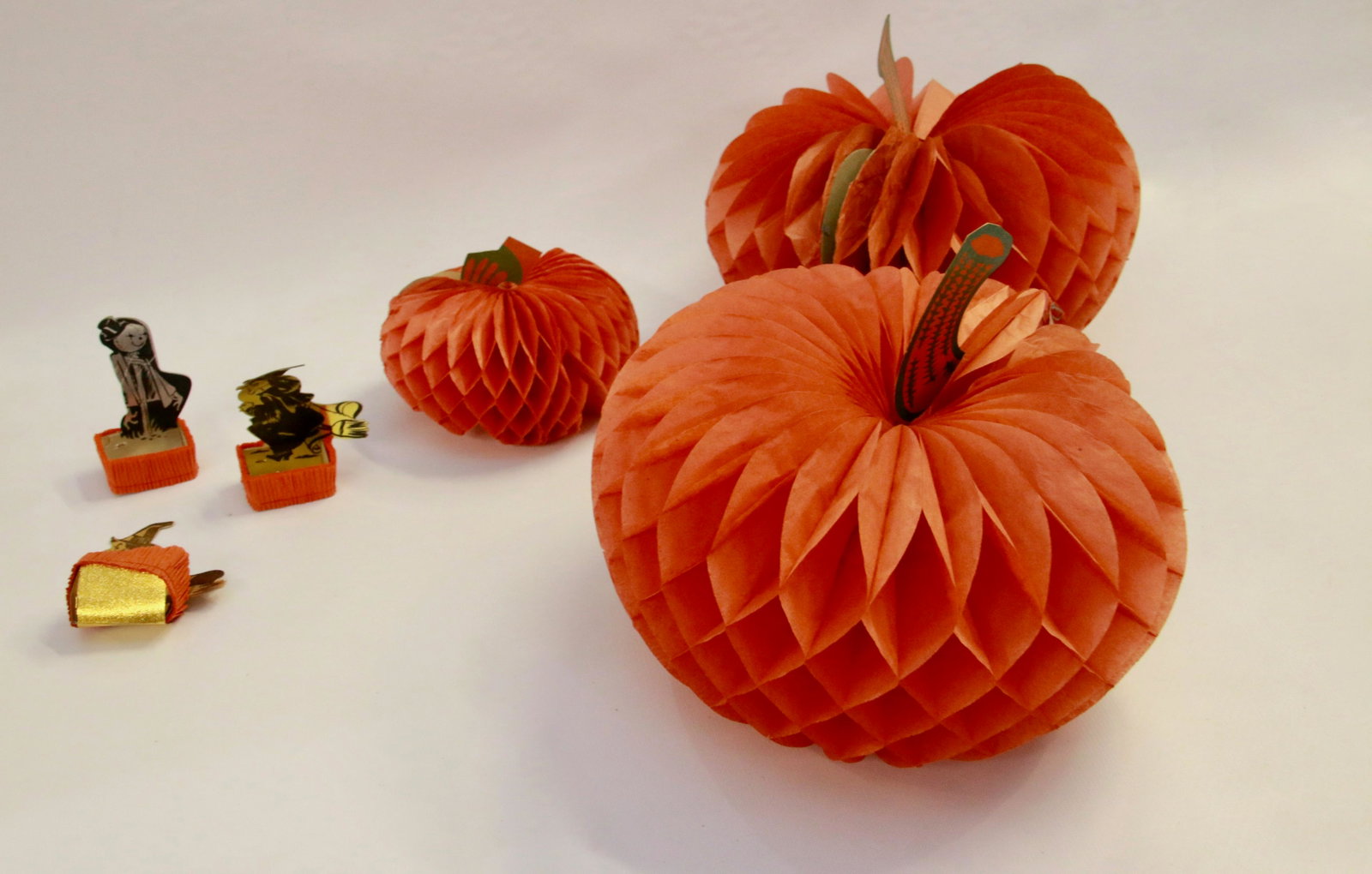 GROUP LOT OF CREPE PAPER HALLOWEEN DECORATIONS: SIX INCLUDING: THREE PUMPKINS AND THREE TREAT HOLDERS Size: PUMPKINS MEASURE 5 1/2" TO 9 1/2" H.