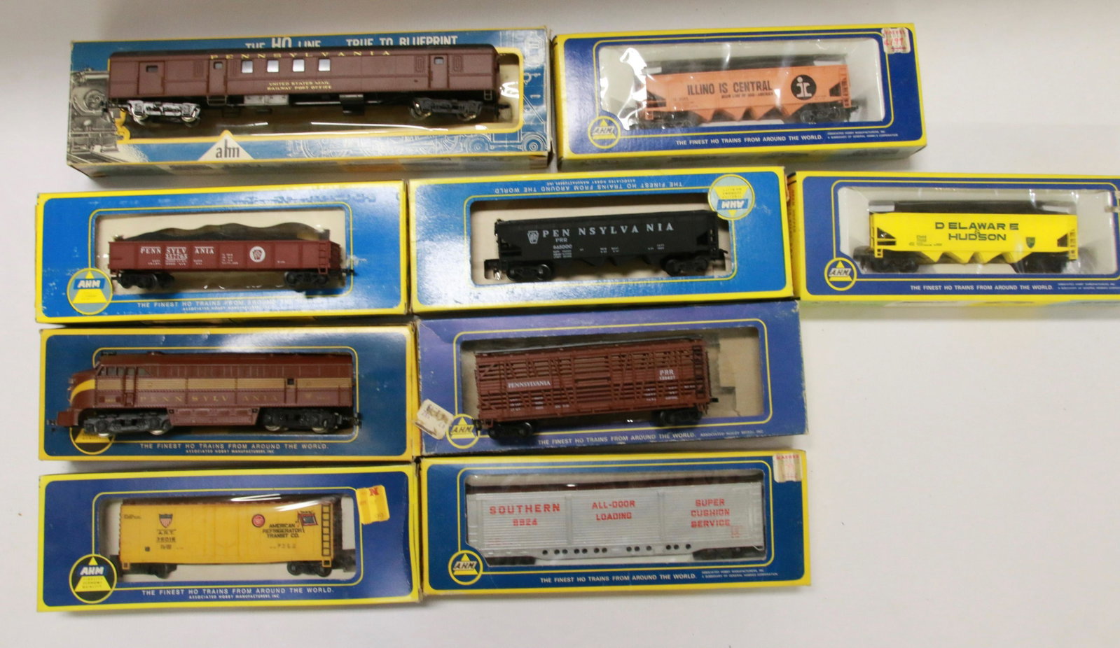 GROUP LOT OF A.H.M. HO SCALE TRAINS: NINE INCLUDING: PENNSYLVANIA #9506 ENGINE, R.P.O 6422 CAR, PENNSYLVANIA GONDOLA, PENNSYLVANIA HOPPER, PENNSYLVANIA CATTLE CAR AND MORE.