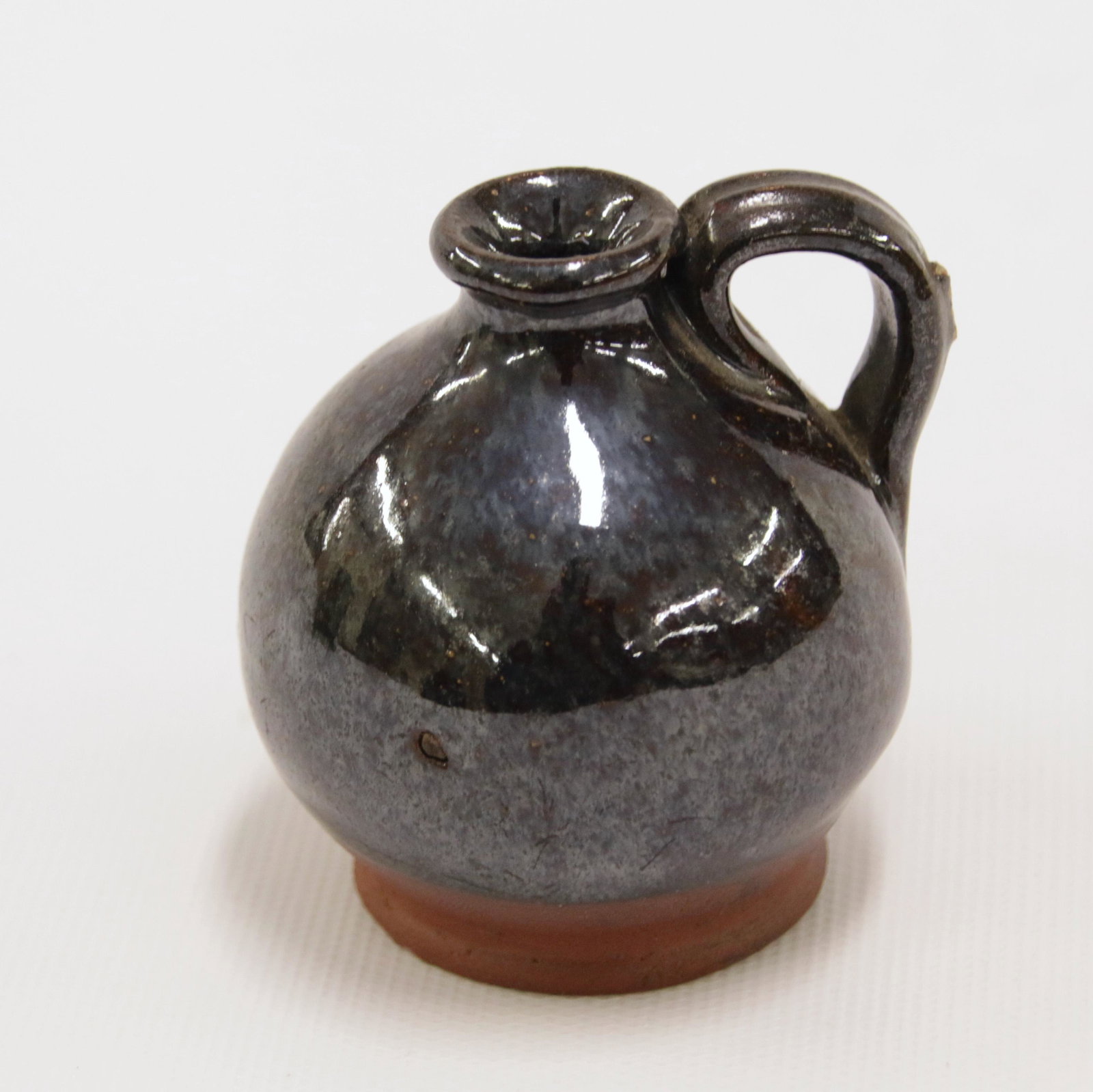 MINIATURE REDWARE JUG: 19TH CENTURY BALL SHAPED JUG - PENNSYLVANIA WITH STRAP HANDLE Size: 2" H X 1 1/2" BASE We do not give IN-HOUSE shipping quotes. Please email japakmail@earthlink.net - All items once paid will be taken