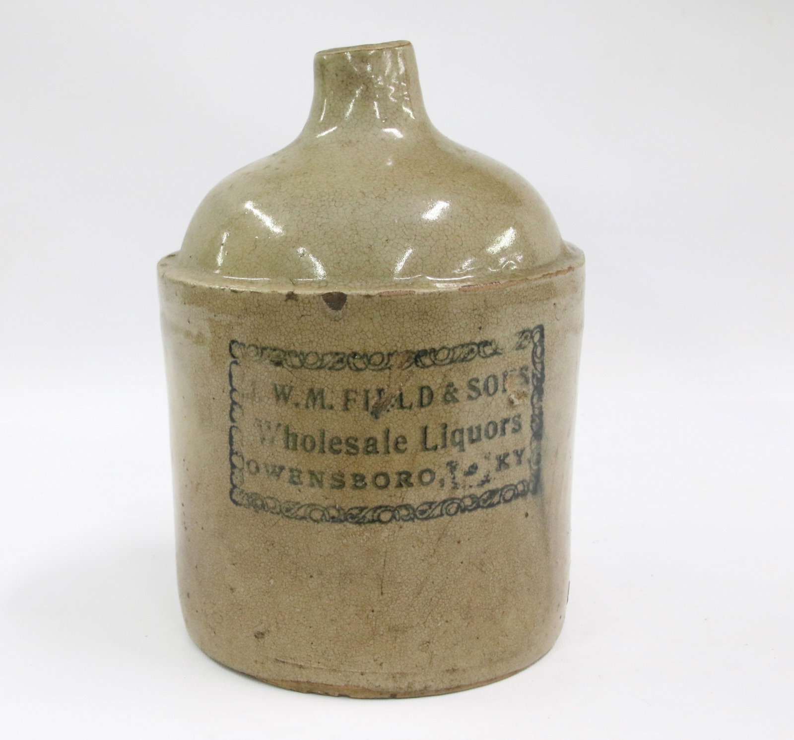 STONEWARE STENCILED ADVERTISING JUG: BLACK STENCIL READS "W.M. FIELD & SONS WHOLESALE LIQUORS, OWENSBORO, KY" Size: 10 1/2" H. We do not give IN-HOUSE shipping quotes. Please email japakmail@earthlink.net - All items once paid will be ta