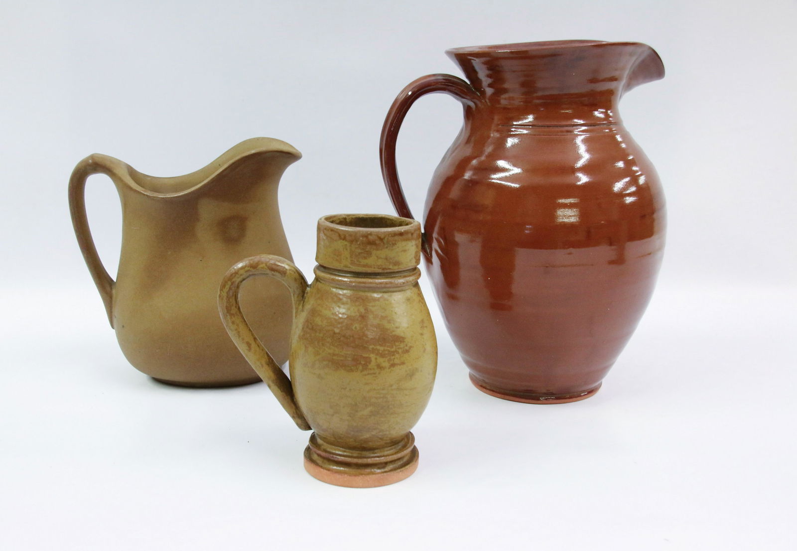 GROUP OF CONTEMPORARY POTTERY PIECES: INCLUDING: MUG IN YELLOW GLAZE MARKED ON BOTTOM "FROM OUT OF THE DUST, RG (ROBERT GRISWOLD) 2017". REDWARE MILK PITCHER MARKED "OLD STURBRIDGE VILLAGE" AND SMALL PITCHER MARKED "BENNINGTON POTTERS REP