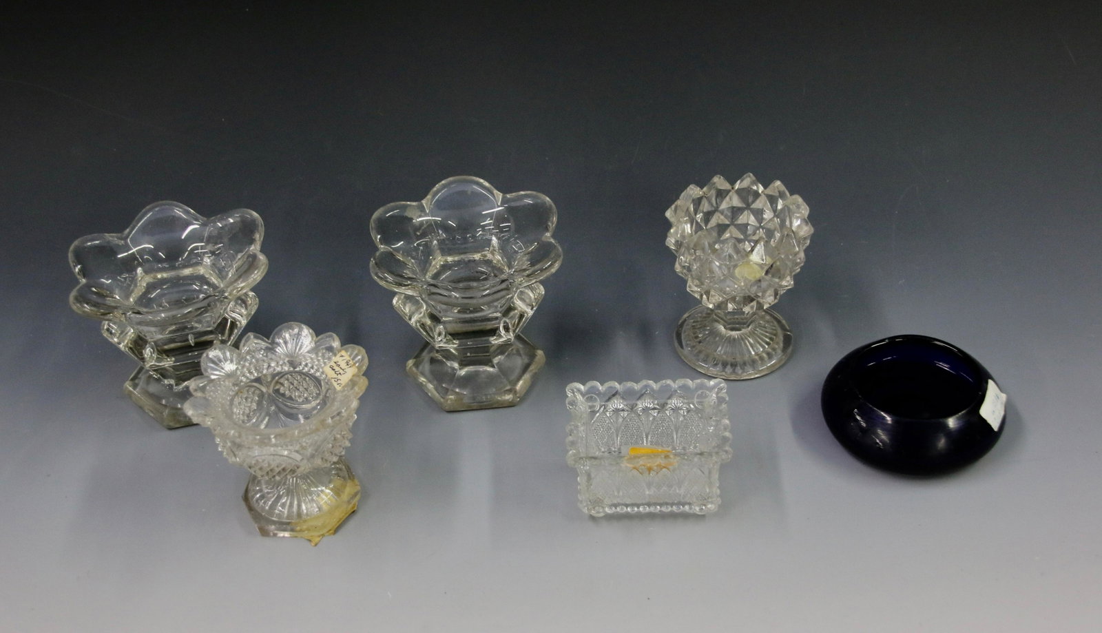 EARLY PRESSED MASTER SALTS: RECTANGLE GOTHIC ARCH LACY, FRENCH LACY, PAIR OF PETAL RIMS WITH POLISHED PONTILS, SAWTOOTH EGG CUP, AND COBALT BLUE POLISHED PONTIL Important Shipping Information: We do not give IN-HOUSE shipping qu